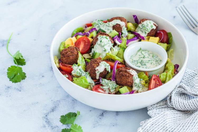 Ensalada con falafel y aliño de tahini.