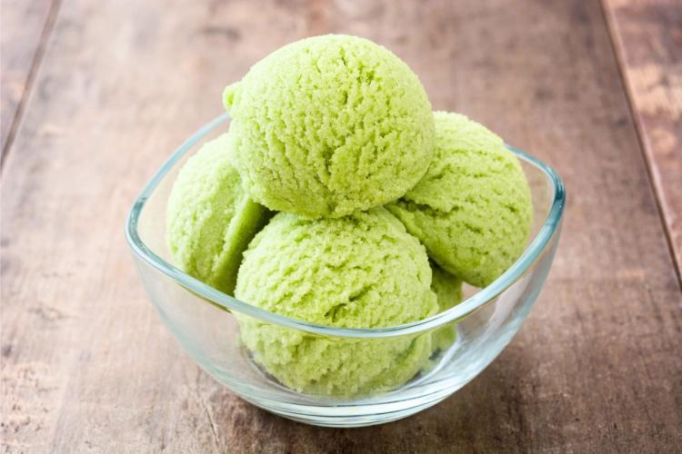 Un cuenco de vidrio con cuatro bolas de helado de matcha.
