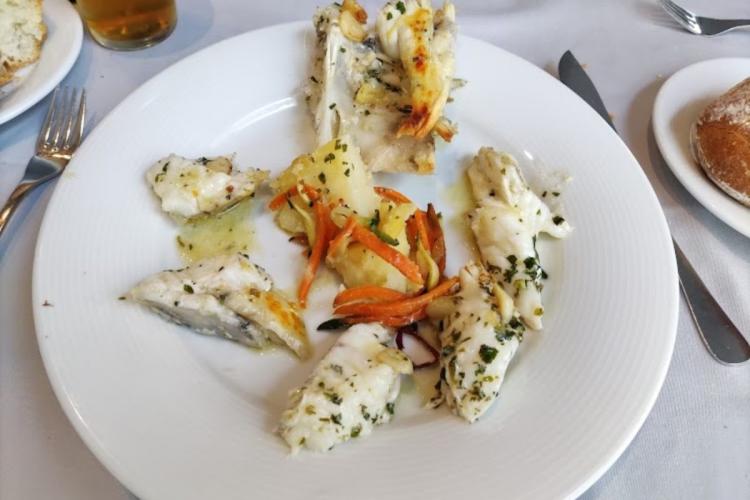 Cocochas de merluza en salsa verde decoradas con tiras de pimiento rojo asado.