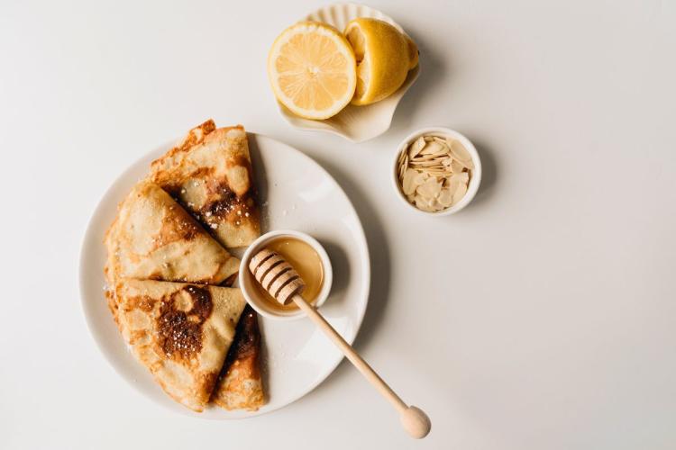 Crêpes dobladas en forma de triángulo con azúcar, miel y limón.