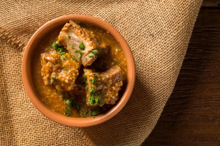 Un cuenco con canjiquinha braseileña, costillas en salsa.