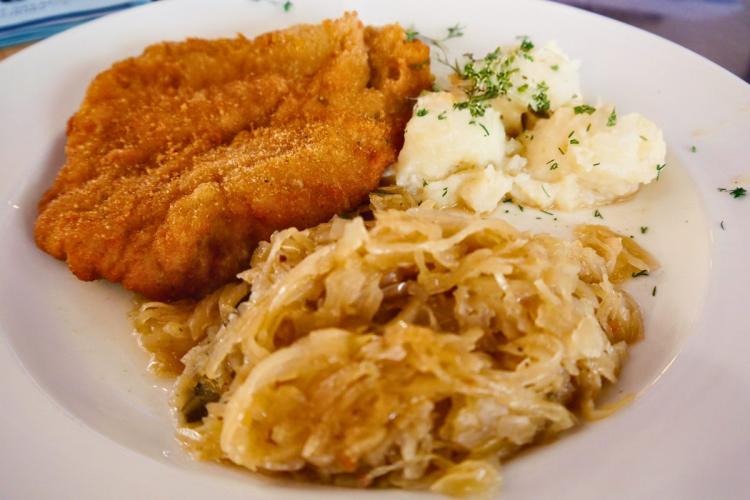 Un plato con un filete de cerdo empanado acompañado con repollo encurtido y puré de patata, al estilo polaco.