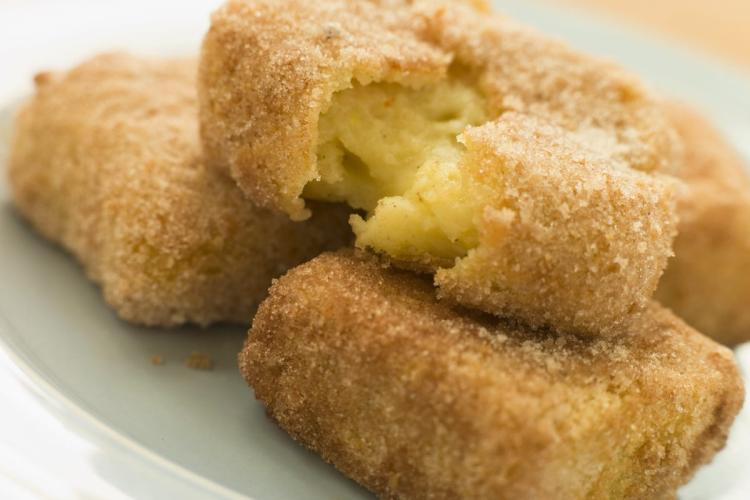 Detalle de leche frita hecha con crema de huevo. Un trozo está abierto para que se pueda apreciar el interior.