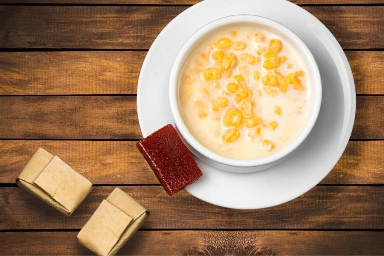 Un cuenco con mazamorra colombiana con dulce de guava al lado.