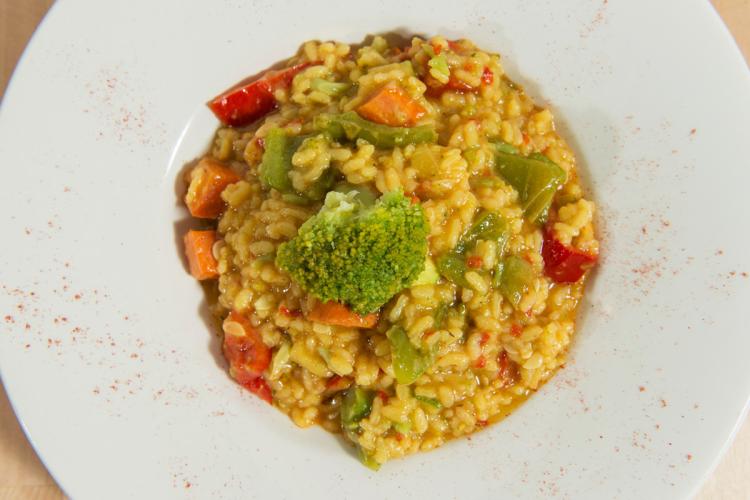 Un plato de arroz caldoso con verduras.