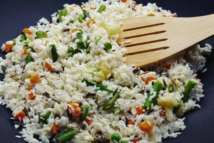 Arroz salteado con verduras todavía en la sartén.