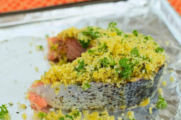 Una rodaja de salmón con costra de pan rallado lista para el horno.