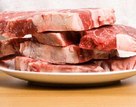 Cuatro filetes de carne en un plato blanco de loza.