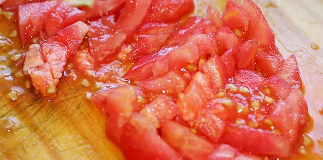 Tomate picado sobre una tabla de madera.