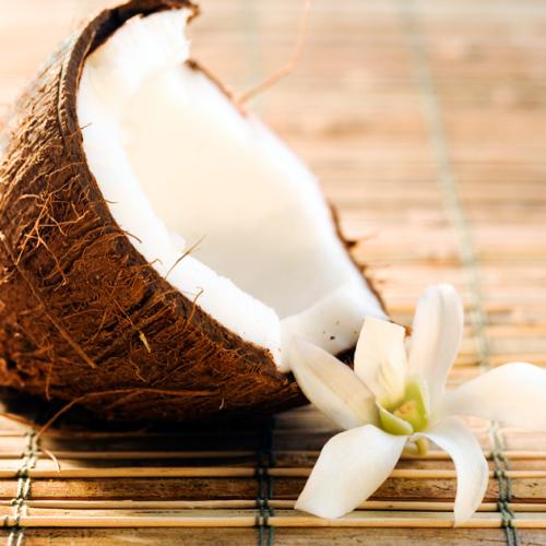 Medio coco abierto y flores tropicales.