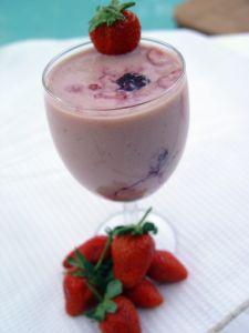 Batido de fresa servido en copa y decorado con fruta fresca.