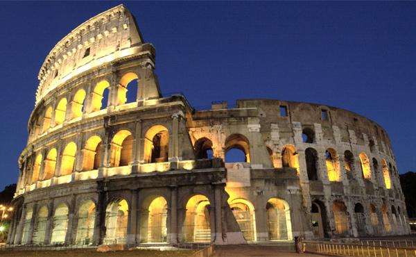 El Coliseo romano por la noche, iluminado.