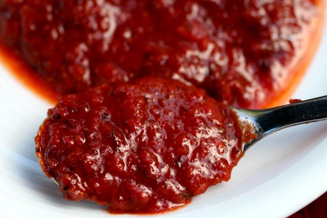 Una cucharita con harissa, mas harissa en un plato.