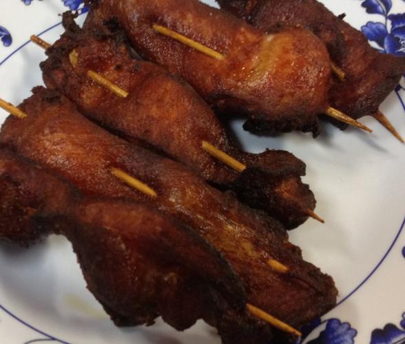 Varios pinchos de pollo teriyaki, ya cocinados, en un plato.