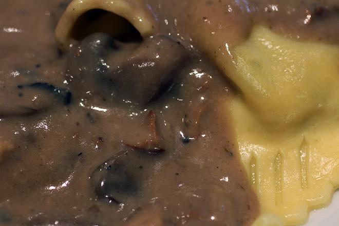 Ravioli cubierto con salsa de boletus.