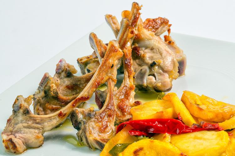 Chuletitas de cordero com patatas y pimientos fritos.