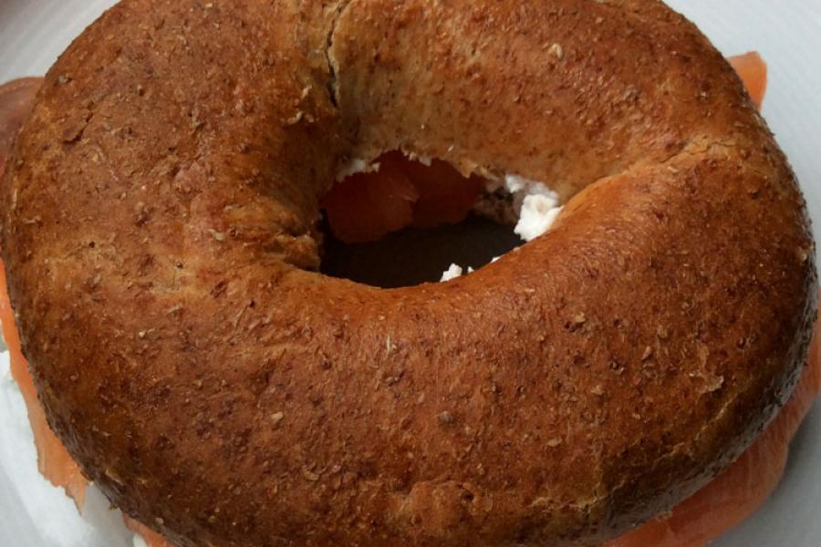 Bagel de hairna integral con salmón ahumado y queso cremoso.