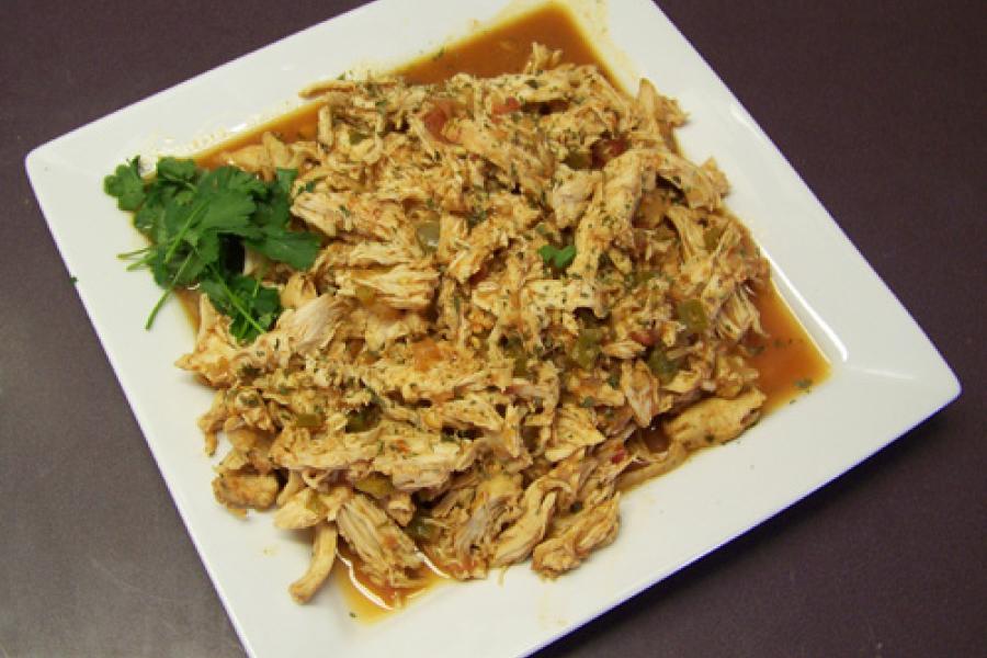 Una fuente con pollo con cilantro y lima desmenuzado.