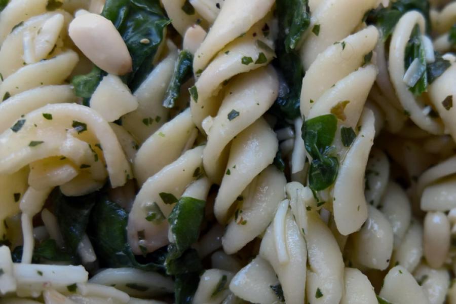Ensalada de espirales de pasta, espinacas tiernas y piñones con aliño.