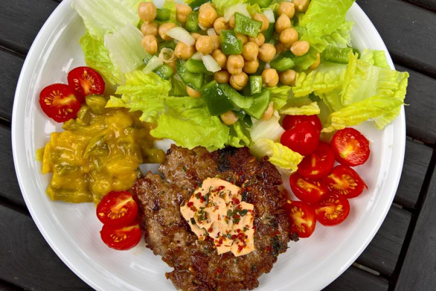 Hamburguesas de cordero con lechuga, tomate, garbanzos y picalilli.