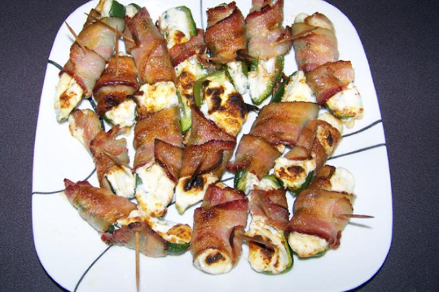 Una fuente con petardos jalapeños, chiles rellenos de queso y envueltos en bacon.
