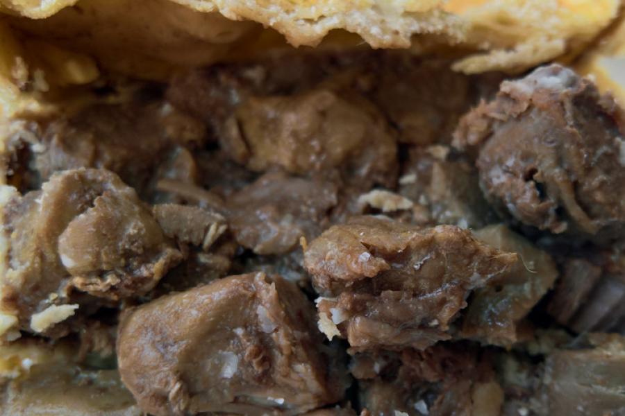 Sección de un pastel de carne y riñones mostrando el relleno.