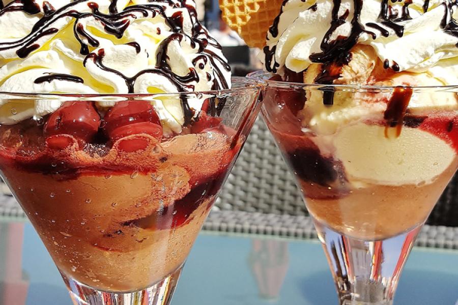 Dos copas con mousse de chocolate y cerezas decorado con nata montada.
