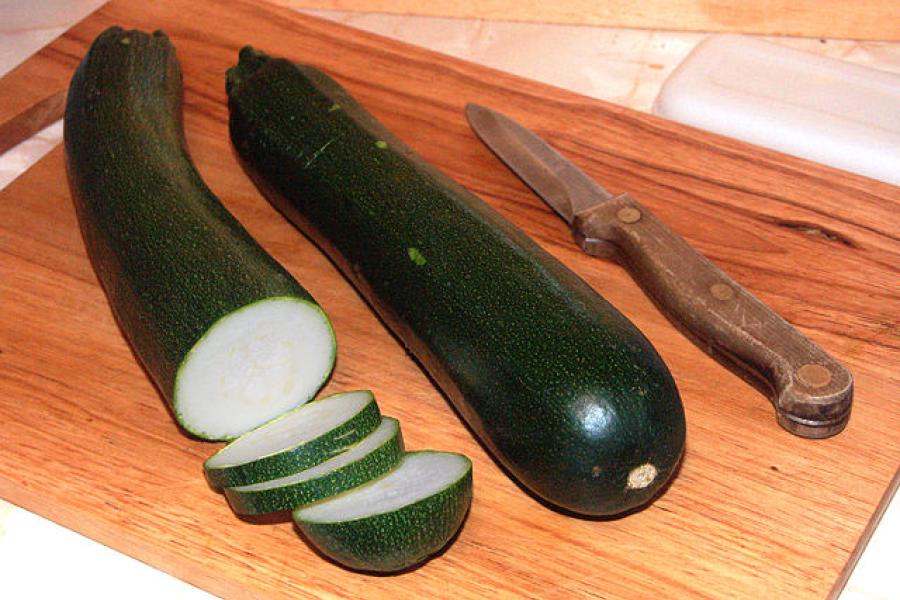 Calabacines sobre una tabla de cocina con un cuchillo al lado.
