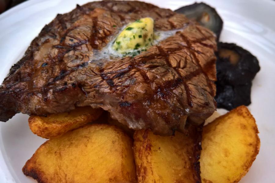 Filete de vacuno a la parrilla con patatas fritas.