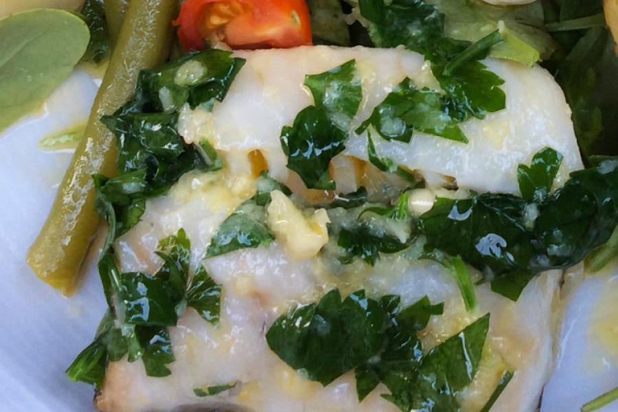 Merluza al horno con mantequilla sazonada con ajo y perejil.