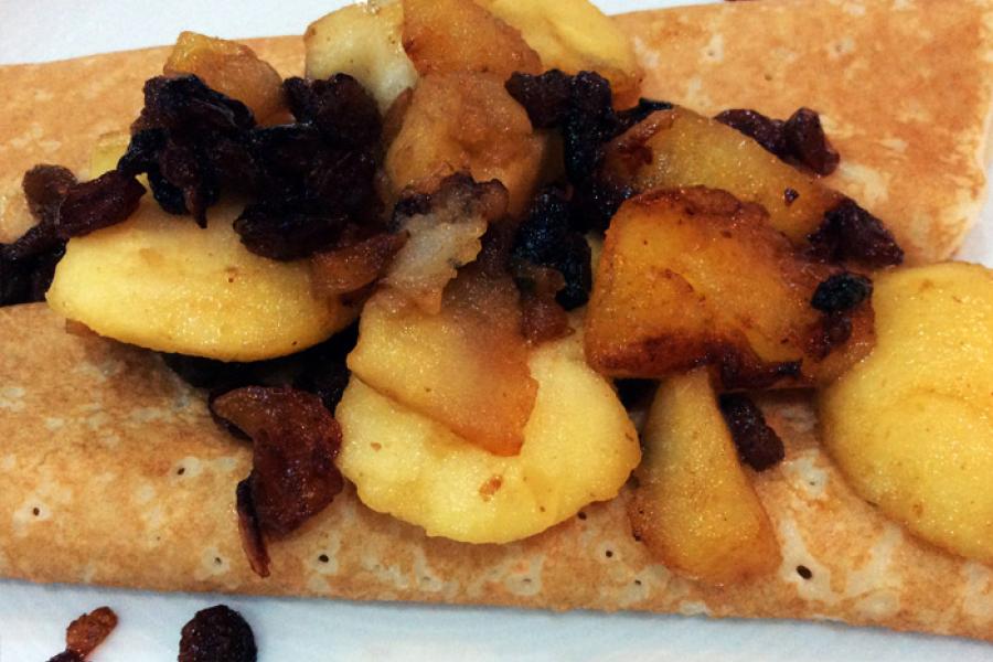 Crepes con manzana frita en mantequilla y uvas pasas.