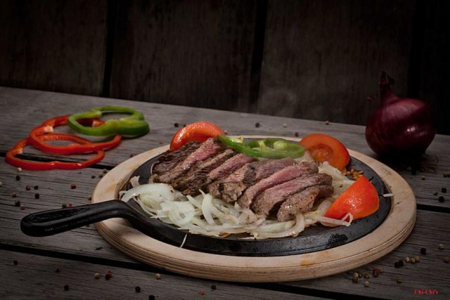 Fajitas de carne con pimiento, cebolla y tomate.