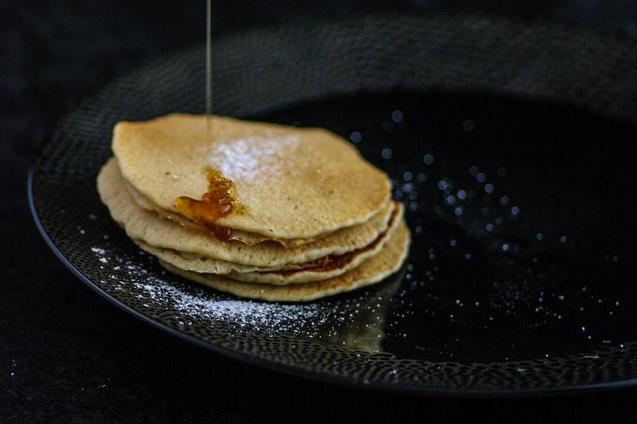 Jarabe de arce cayendo sobre tortitas.