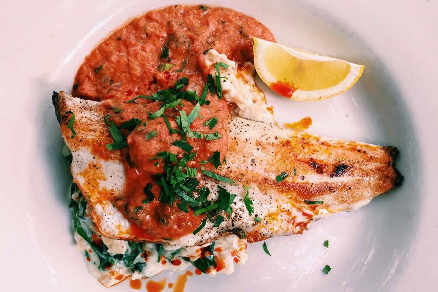 Pescado a la parrilla con salsa de tomate.