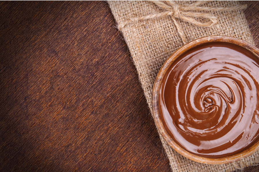 Crema de chocolate en una tarrina individual sobre una servilleta rústica.