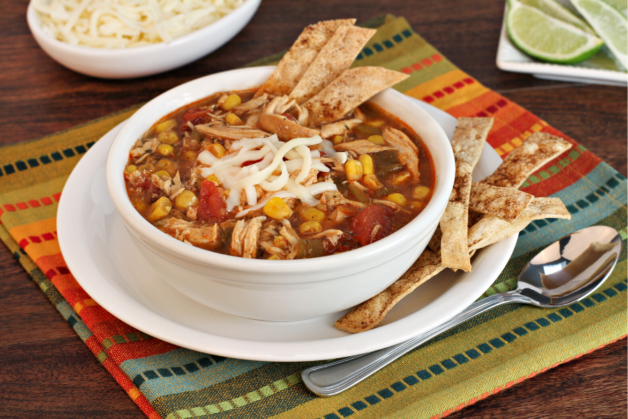 Sopa de pollo y tortilla de maíz en un cuenco.
