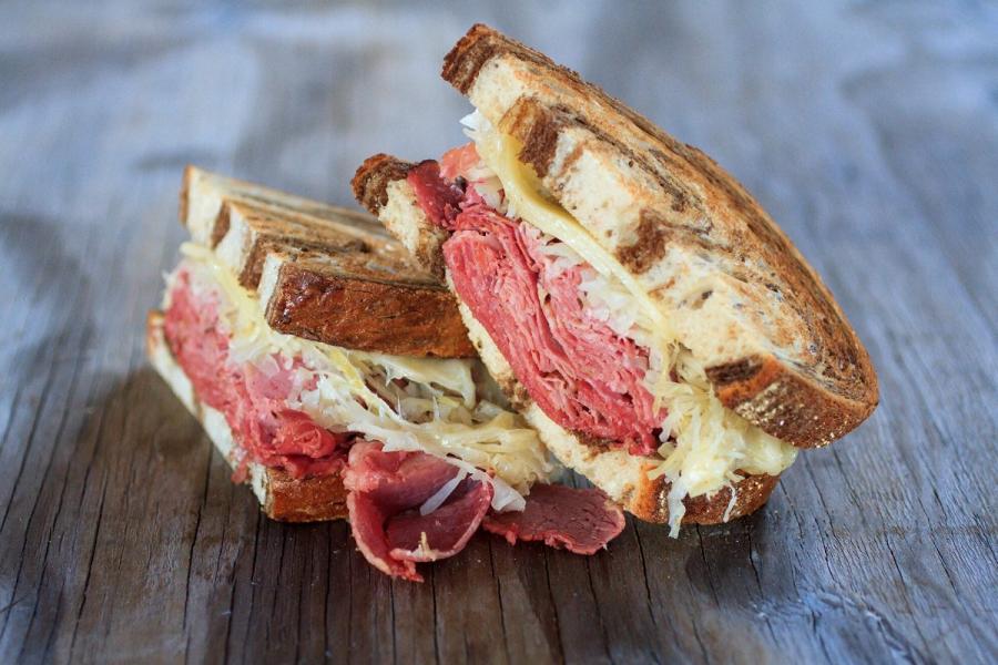 Bocadillo Reuben con corned beef ahumado, queso y sauerkraut.