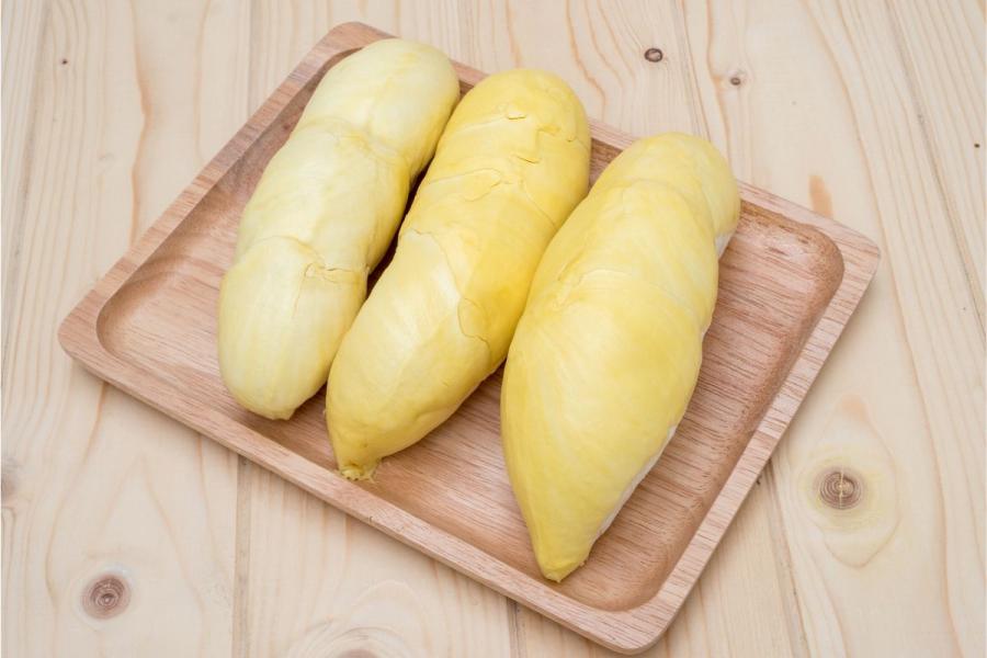 Tres trozos de pulpa de durián sobre una tabla.