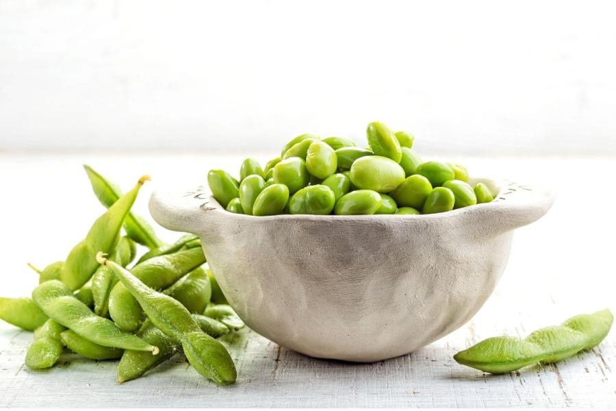 Vainas de edamame y semillas desgranadas en un tazón.