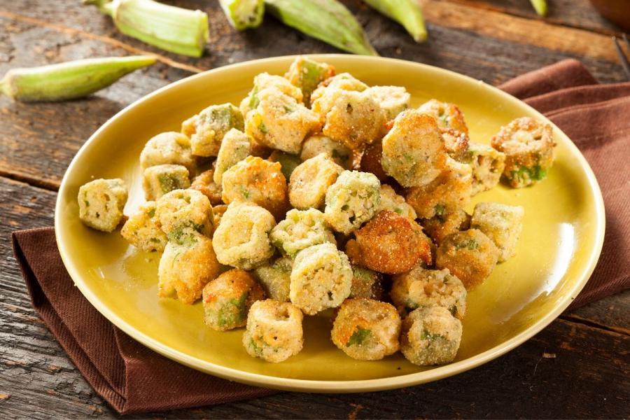 Ocra rebozada y frita en un plato de loza.