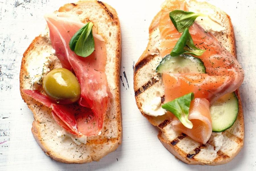 Tostada con jamón y aceituna y tostada con salmón ahumado y pepino.