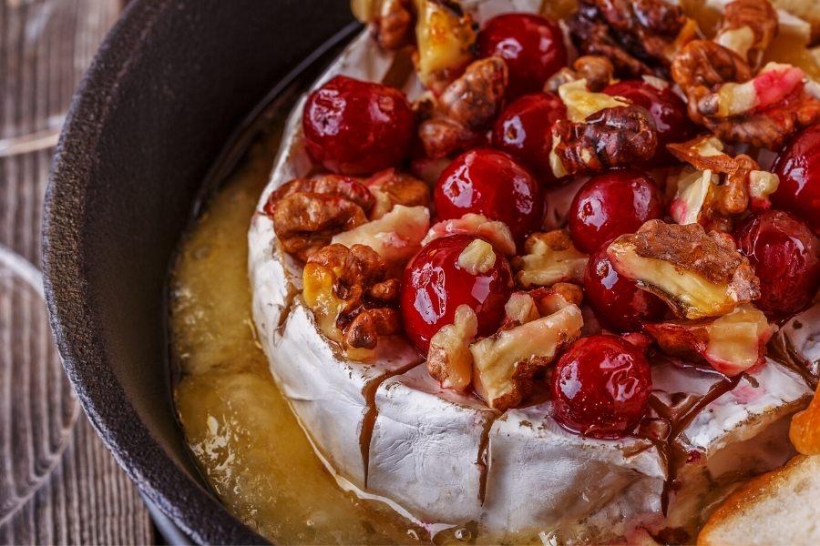 Queso brie al horno con arándanos frescos y nueces.