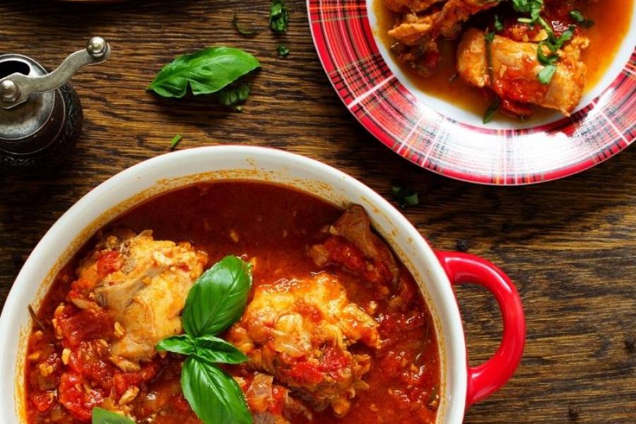 Conejo con tomate y albahaca en una cazuela.