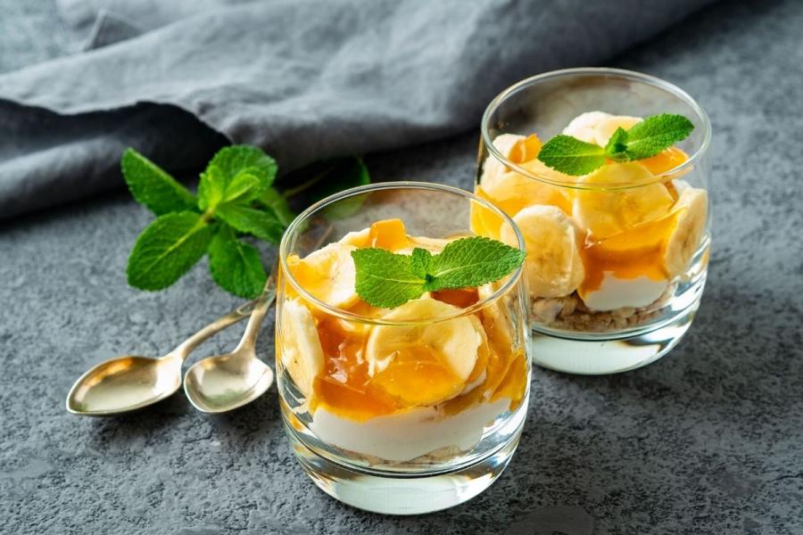 Copas de plátano y yogur decoradas con hojas de menta.