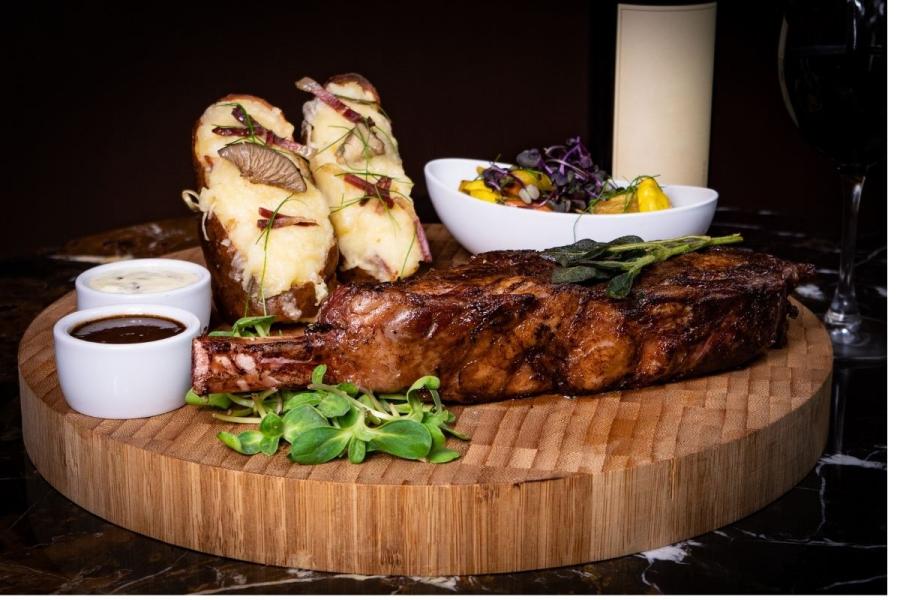 Filete de búfalo, o bisonte americano, a la parrilla servido con salsa y guarniciones.