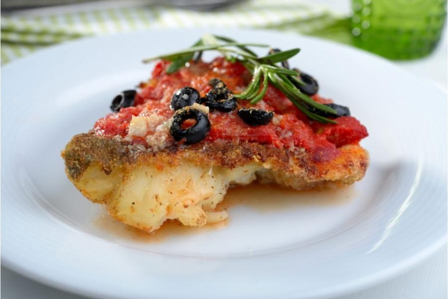 Bacalao al horno con salsa de tomate y aceitunas negras.