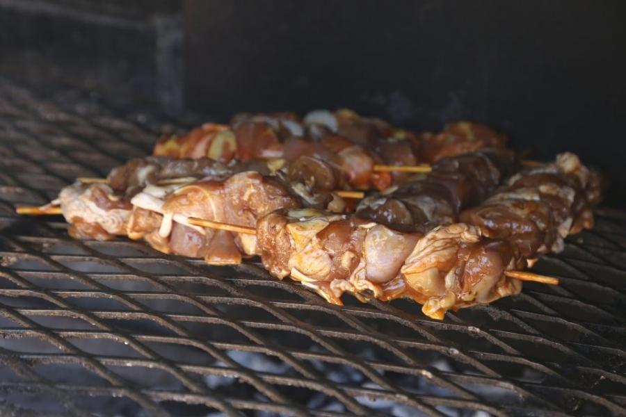 Sosaties de pollo sobre la parrilla de una barbacoa de carbón.