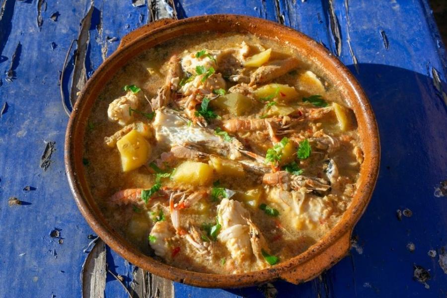 Suquet de peix, o suquet de pescado, con cigalas servido en cazuela de barro.