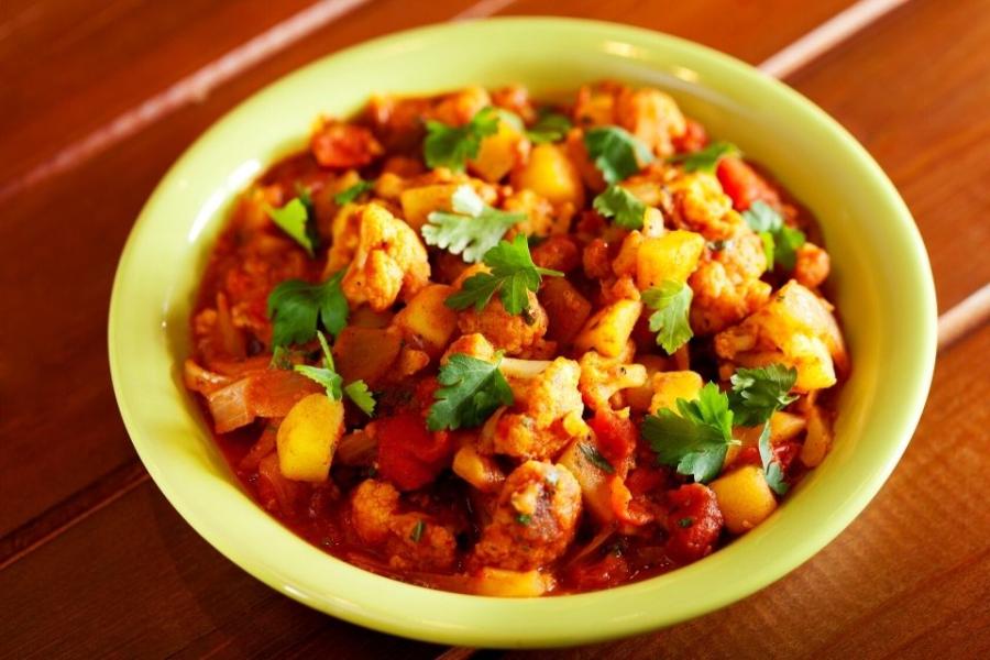 Un plato hondo con aloo gobi, un curry de coliflor y patata.