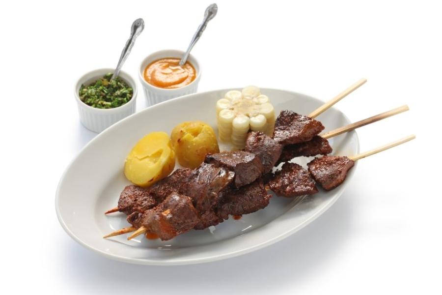 Anticuchos de corazón con dos salsas.